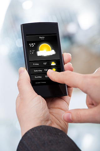 Businesswoman Checking Weather Forecast On Smartphone